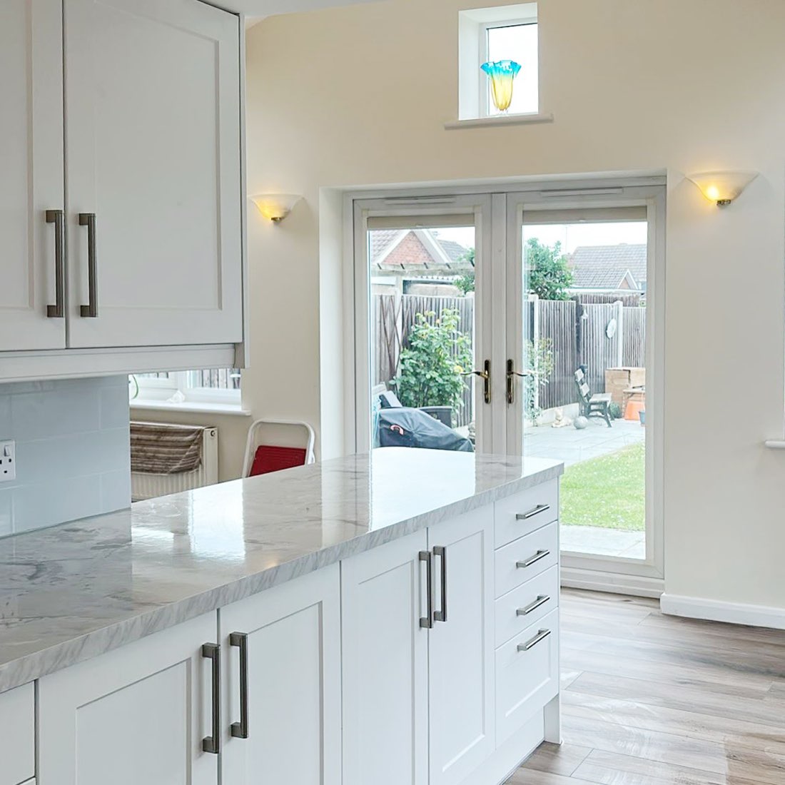 Bright open-plan kitchen with island and French doors to the garden